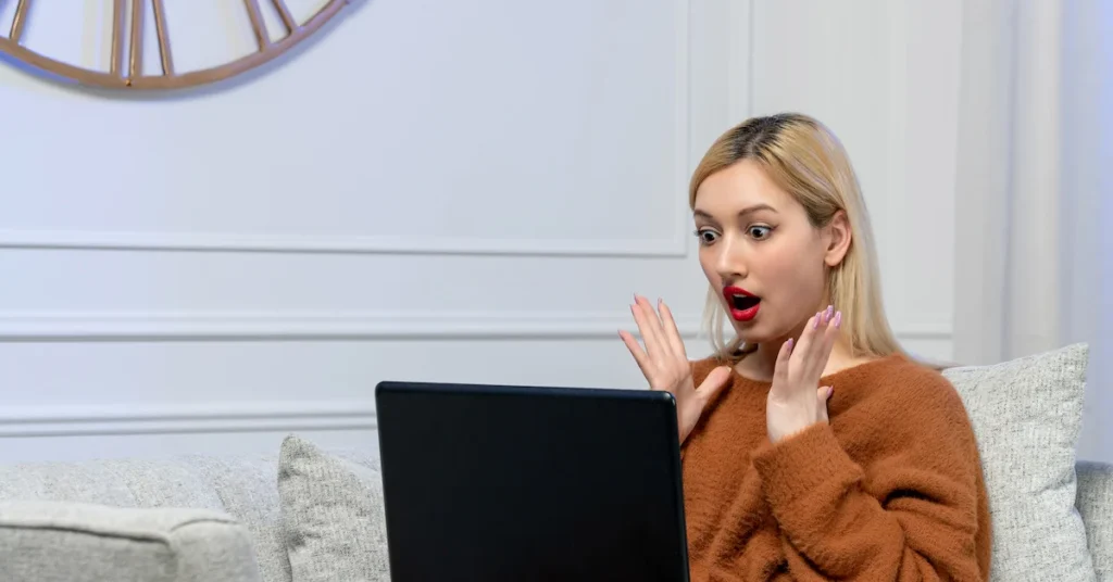 virtual-love-cute-young-blonde-girl-cozy-sweater-computer-distance-date-shocked